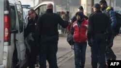 FILE - Police forces arrest migrants as they evacuate their camp in Calais, Feb. 21, 2019..