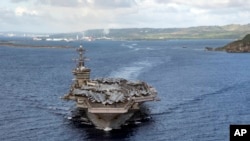 File - In this June 4, 2020, photo provided by the U.S. Navy, the aircraft carrier USS Theodore Roosevelt (CVN 71) departs Apra Harbor in Guam. 