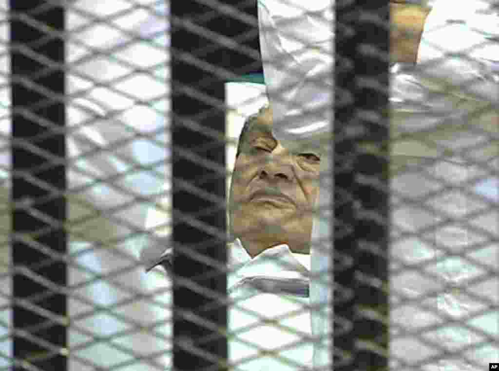 Video image taken from Egyptian State Television showing former President Hosni Mubarak, 83, laying on a hospital bed inside a cage in a Cairo courtroom as his historic trial began on charges of corruption and ordering the killing of protesters during the