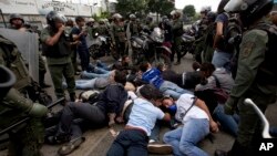 Militares venezolanos rodean a un grupo de estudiantes y manifestantes opositores detenidos el 14 de mayo de 2014 en Caracas. Un fiscal en Argentina imputó este jueves a comandantes y miembros de la Guardia Nacional Bolivariana venezolana por esas represiones.