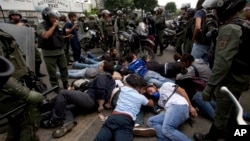 ARCHIVO - Militares de la Guardia Nacional Bolivariana de Venezuela rodean a un grupo de manifestantes detenidos en Caracas, el 14 de mayo de 2014.