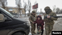 Anggota unit Malaikat Putih dari Kepolisian Ukraina mengevakuasi seorang lansia dari wilayah garis depan pertempuran di Pokrovsk, Donestk, pada 7 Februari 2025. (Foto: Reuters/Oleksandr Klymenko)