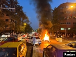 Sebuah sepeda motor polisi dibakar massa saat protes atas kematian Mahsa Amini, yang meninggal setelah ditangkap oleh "polisi moral" di Teheran, Iran 19 September 2022. WANA (Kantor Berita Asia Barat) via REUTERS.