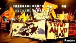 Protesters carry banners during a demonstration against U.S. President Donald Trump, ahead of Trump's visit to the World Economic Forum (WEF), in Zurich, Switzerland, Jan. 23, 2018.