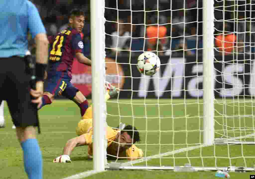 Neymar, à gauche, marque un but contre Gianluigi Buffon, lors du dernier match de football entre la Juventus Turin et le FC Barcelona au stade olympique de Berlin, le 6 juin 2015.