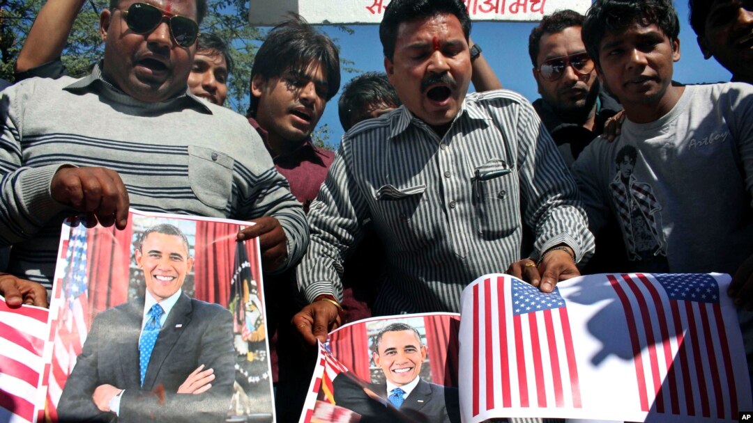 Para aktivis forum budaya Sanskriti Bachao Manch di Bhopal, India, membakar poster Presiden AS Barack Obama dan bendera AS dalam demonstrasi yang memprotes dugaan perlakuan tak baik atas diplomat India di New York, Devyani Khobragade. (AP/Rajeev Gupta)