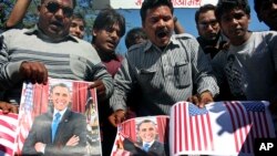 Para aktivis forum budaya Sanskriti Bachao Manch di Bhopal, India, membakar poster Presiden AS Barack Obama dan bendera AS dalam demonstrasi yang memprotes dugaan perlakuan tak baik atas diplomat India di New York, Devyani Khobragade. (AP/Rajeev Gupta)