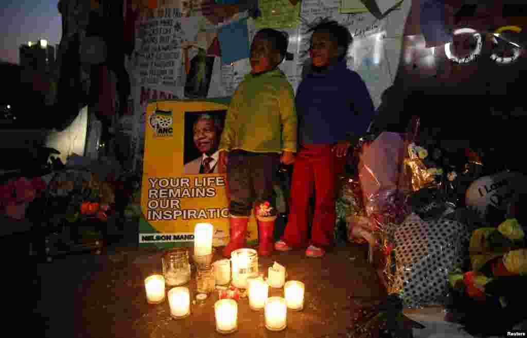 Children sing "Happy Birthday" in front of messages of support outside the hospital where Nelson Mandela is being treated, Pretoria, July 17, 2013.