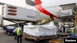 Workers offload boxes of AstraZeneca/Oxford vaccines as the country receives its first batch of coronavirus disease (COVID-19) vaccines under COVAX scheme, at the international airtport of Accra, Ghana, Feb. 24, 2021.