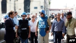 A team of United Nations observers tours the Syrian town of al-Haffe with an official Syrian security escort, June 14, 2012. 