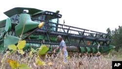 FILE - A farmer checks his combine as he gets ready to harvest his soybean crop at his farm in Turbeville, South Carolina, Oct. 5, 2016.