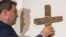 Markus Soeder, Governor of the German state of Bavaria, hangs up a cross at the entrance of the state chancellery in Munich, Germany, April 24, 2018. 