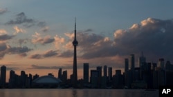 The sun sets over the Toronto skyline during the opening ceremony for the Pan Am Games, July 10, 2015. 