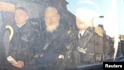 Pendiri WikiLeaks Julian Assange (tengah) di dalam mobil van polisi, meninggalkan pengadilan di London, Inggris, Kamis (11/4). 