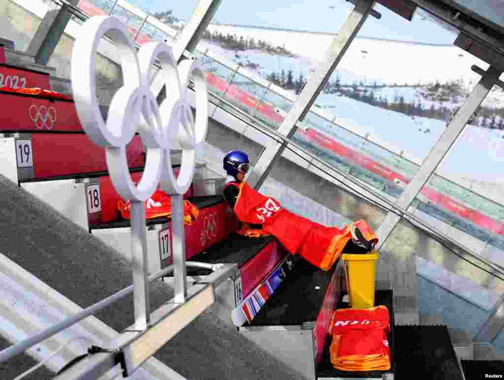 Kobayashi Ryoyu of Japan sits under a blanket as he waits to compete in men&#39;s ski jumping during the 2022 Beijing Olympics, at the National Ski Jumping Centre, in Zhangjiakou, China.