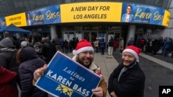 People wait under a light rain outside the Microsoft Theater to attend the inauguration ceremony of Karen Bass, the first Black woman elected Los Angeles mayor in Los Angeles on Dec. 11, 2022.