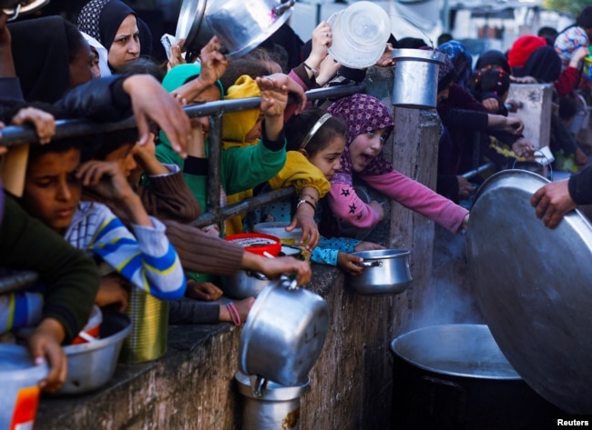 Anak-anak Palestina menunggu untuk menerima makanan selama bulan suci Ramadhan di Rafah, di Jalur Gaza selatan, 13 Maret 2024. (Foto: REUTERS/Mohammed Salem)