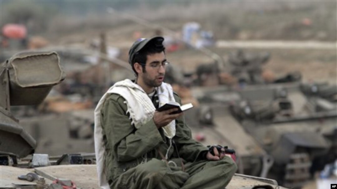 Seorang tentara Israel tengah berdoa sambil berjaga di perbatasan dekat Gaza, selatan Israel (22/11). (AP/Lefteris Pitarakis)