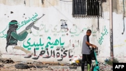 A Palestinian youth rides his scooter in the Tulkarem refugee camp in the West Bank on November 7, 2023, following an overnight raid by Israeli troops amid ongoing battles with Hamas.