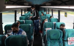 Passengers sit on a bus at the terminal for long-distance travel in Bogota, Colombia, Sept. 1, 2020. Airports, land transport, restaurants, and gyms are reopening in most of Colombia this week.