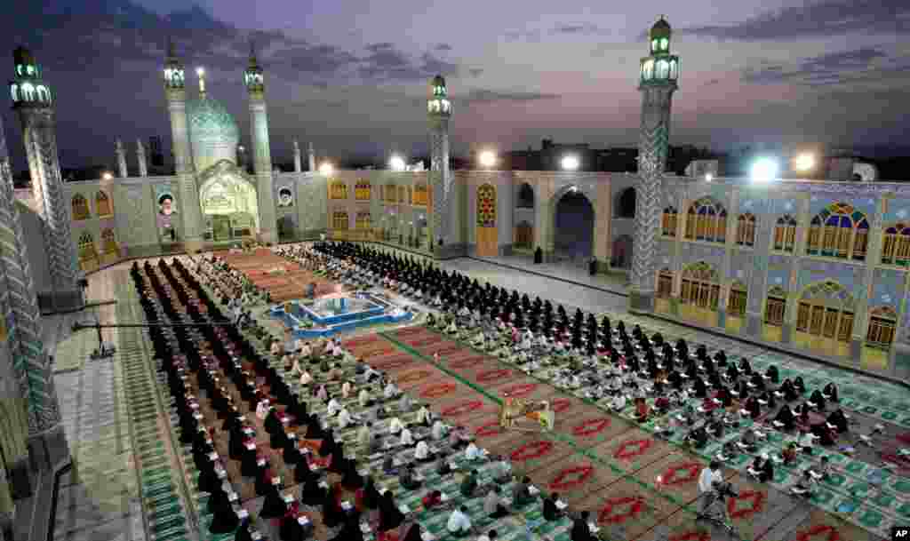 Men and women recite verses of the Quran at the shrine of Saint Mohammad Helal Ibn Ali, in the city of Aran and Bidgol, Iran, August 1, 2012.
