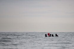FILE - Migrants navigate a boat in agitated waters between Sangatte and Cap Blanc-Nez, in the English Channel off the coast of northern France, as they attempt to cross the maritime borders between France and the United Kingdom, Aug. 27, 2020.