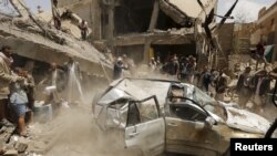 A car falls as it is being lifted by a crane at the site of a Saudi-led air strike in Yemen's capital Sanaa September 21, 2015. 