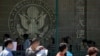 FILE - Visa applicants wait to enter the U.S. Embassy in Beijing, China, Thursday, July 26, 2018. 