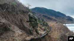 En esta fotografía proporcionada por el Ministerio de Defensa japonés, miembros de las Fuerzas de Autodefensa de Japón transportan artículos de socorro a un área aislada en Wajima, prefectura de Ishikawa, Japón, el 7 de enero de 2024.