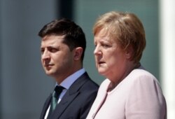 FILE - German Chancellor Angela Merkel, right, and Ukraine's President Volodymyr Zelenskiy attend the welcome ceremony in Berlin, Germany, June 18, 2019.