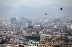 FILE - Birds fly over the city of Kabul, Afghanistan, Jan. 31, 2021. In a report released March 1, 2021, the Special Inspector General for Afghanistan Reconstruction, known as SIGAR, documented massive waste on rebuilding projects in the country.