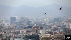 FILE - Birds fly over the city of Kabul, Afghanistan, Jan. 31, 2021. In a report released March 1, 2021, the Special Inspector General for Afghanistan Reconstruction, known as SIGAR, documented massive waste on rebuilding projects in the country.