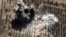 FILE - An image taken from video footage made available on the Russian Defense Ministry's official website purports to show an explosion after airstrikes carried out by Russian air force on what Moscow says was an Islamic State facility in the Syrian province of Idlib, Oct. 15, 2015.