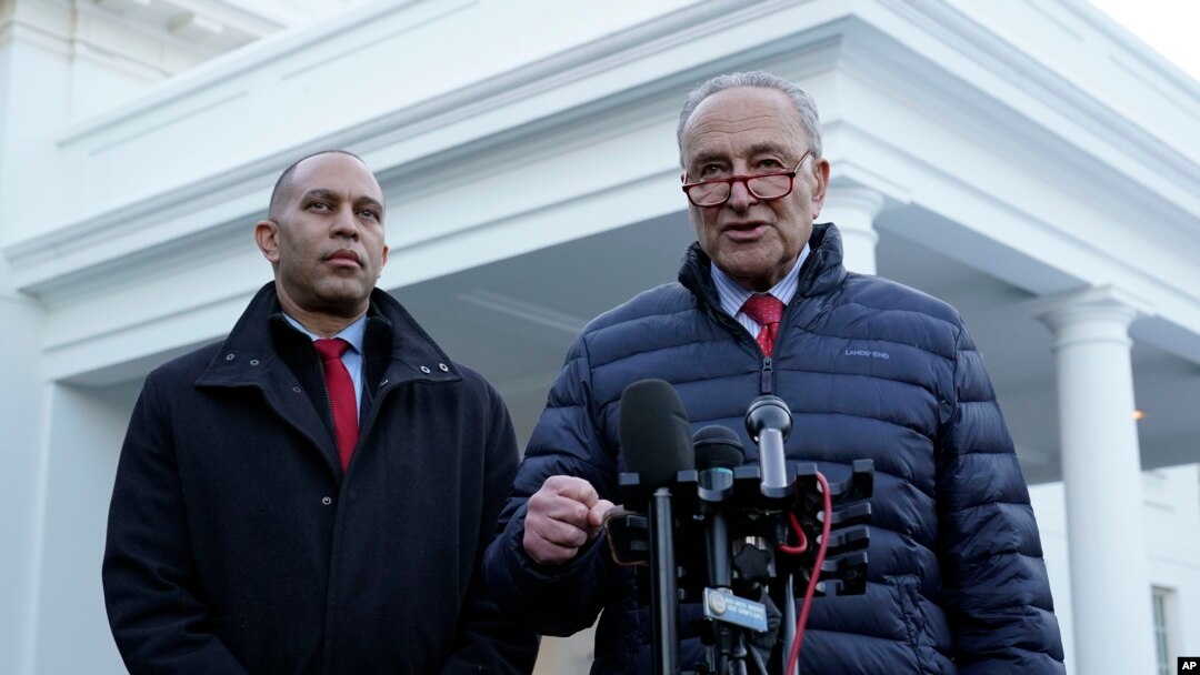 El líder de la mayoría en el Senado, Chuck Schumer, habla con reporteros junto al líder de la minoría en la Cámara de Representantes, Hakeem Jeffries, también en el exterior de la Casa Blanca, el 17 de enero, luego de reunirse con el presidente Joe Biden.