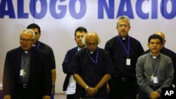 ARCHIVO - El obispo César Bosco Vivas Robelo, izquierda, el cardenal Leopoldo Brenes, centro, y el obispo Rolando Álvarez, oran al final del tercer día del diálogo nacional en Managua, Nicaragua, el 21 de mayo de 2018. (Foto AP/Alfredo Zúñiga, Archivo)