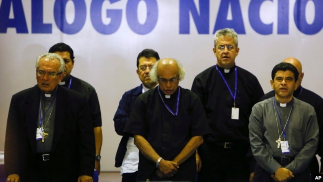 ARCHIVO - El obispo César Bosco Vivas Robelo, izquierda, el cardenal Leopoldo Brenes, centro, y el obispo Rolando Álvarez, oran al final del tercer día del diálogo nacional en Managua, Nicaragua, el 21 de mayo de 2018. (Foto AP/Alfredo Zúñiga, Archivo)