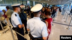 FILE - Police officers are seen patrolling at a security gate inside the main terminal of Frankfurt Airport.