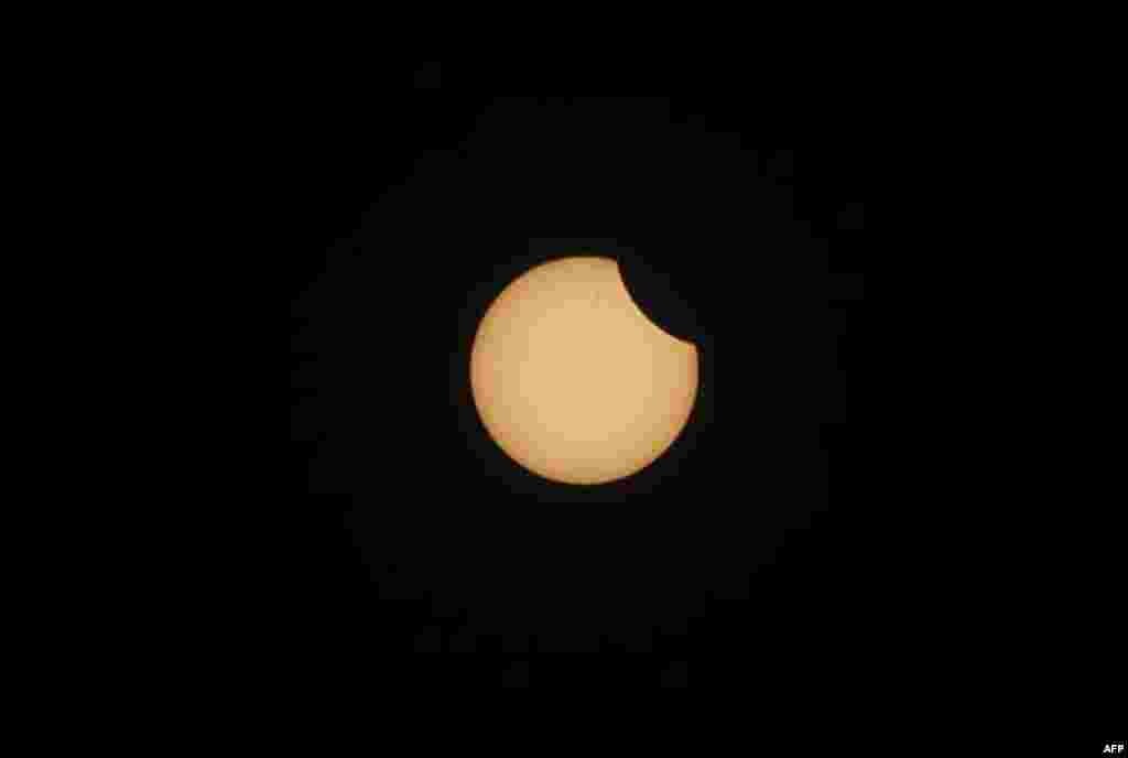 A view of partial solar eclipse, seen through a black film in Srinagar, India, Tuesday, Jan. 4, 2011. People in parts of north India viewed a partial eclipse Tuesday as the moon crossed the sun's path. (AP Photo/Mukhtar Khan)