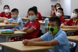 FILE - Primary school students wearing protective masks attend their first day of class after the government eased a nationwide lockdown during the coronavirus disease outbreak in Ho Chi Minh City, Vietnam, May 11, 2020.