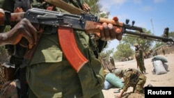 FILE - A fighter stands guard in the southern Somali port city of Kismayo.