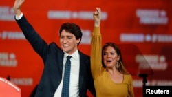 Perdana Menteri Kanada Justin Trudeau dan istrinya, Sophie Gregoire Trudeau melambai kepada pendukungnya di Palais des Congres, Montreal, Selasa (22/10). 