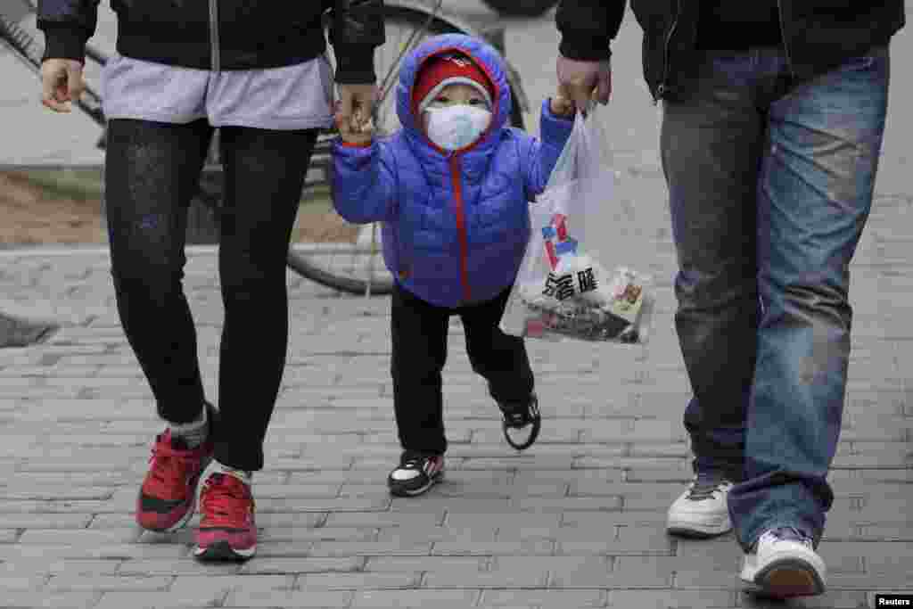 Uma criança usa uma máscara de protecção respiratória devido ao alerta vermelho de poluição emitido pelo governo chinês. Pequim, China, 8 de Dezembro 2015