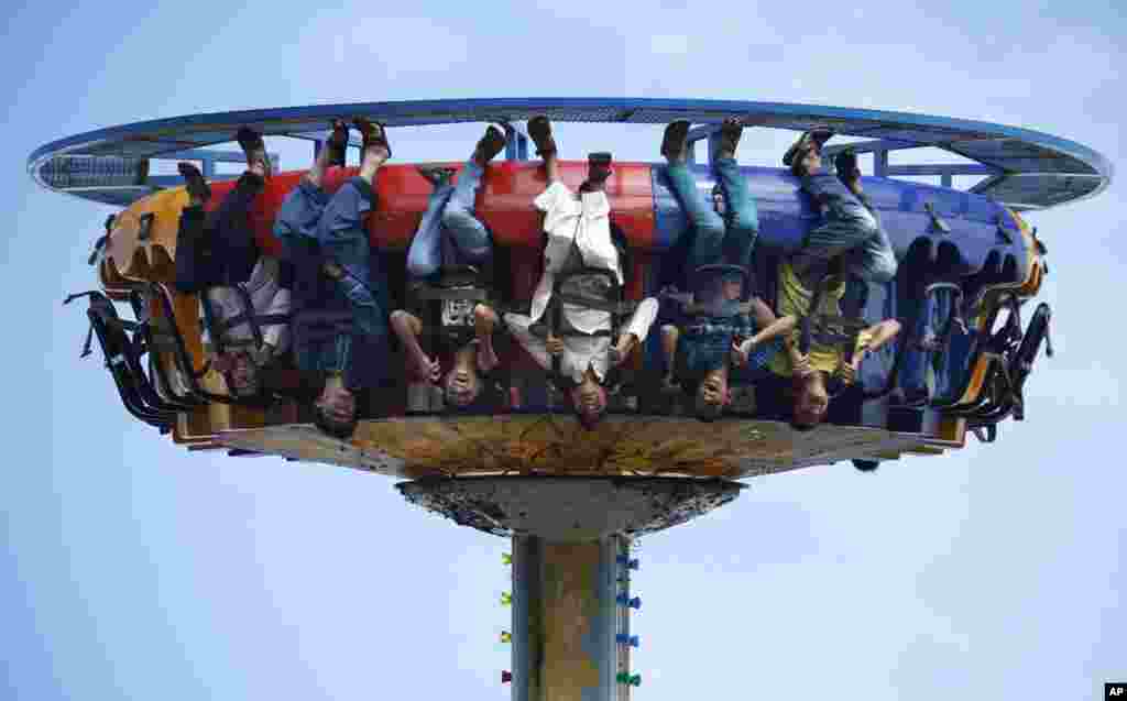 Jovens se divertem num parque de diversões em Rawalpindi, Paquistão, 22 de Julho, 2015.