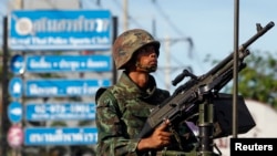 Seorang tentara Thailand memegang senjata mesin di tengah kota Bangkok (20/5). (Reuters/Chaiwat Subprasom)