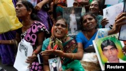 FILE - Tamil women cry as they hold up images of their disappeared family members during the war against Liberation Tigers of Tamil Eelam (LTTE) at a protest in Jaffna north of Colombo, Aug. 27, 2013.