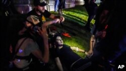 Un grupo de personas asiste a Gaige Grosskreutz un manifestante herido, quien fue presuntamente disparado por el joven Kyle Rittenhouse durante protestas para exigir igualdad racial en Kenosha, Wisconsin, el 25 de agosto.