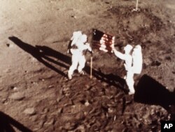 FILE - Apollo 11 astronauts Neil Armstrong and Buzz Aldrin, the first men to land on the moon, plant the U.S. flag on the lunar surface, July 20, 1969.