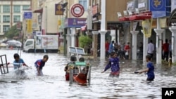 Children play in a flooded street in downtown Kota Bharu, Kelantan, Malaysia.