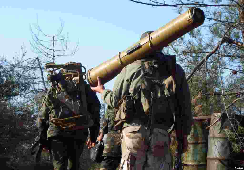 A rebel fighter carries an anti-tank weapon as he heads with his fellow fighters towards their positions in the Armenian Christian town of Kasab, Syria.