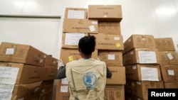 FILE - A World Food Program worker arranges relief packages at a warehouse designated to the United Nations for humanitarian aid for Africa, at the Bole International Airport in Addis Ababa, Ethiopia, April 14, 2020.